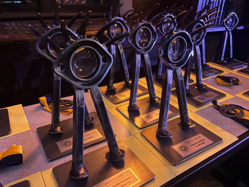 Cinema Eye Honors awards lined up on top of a table waiting to be handed out to 2025 winners